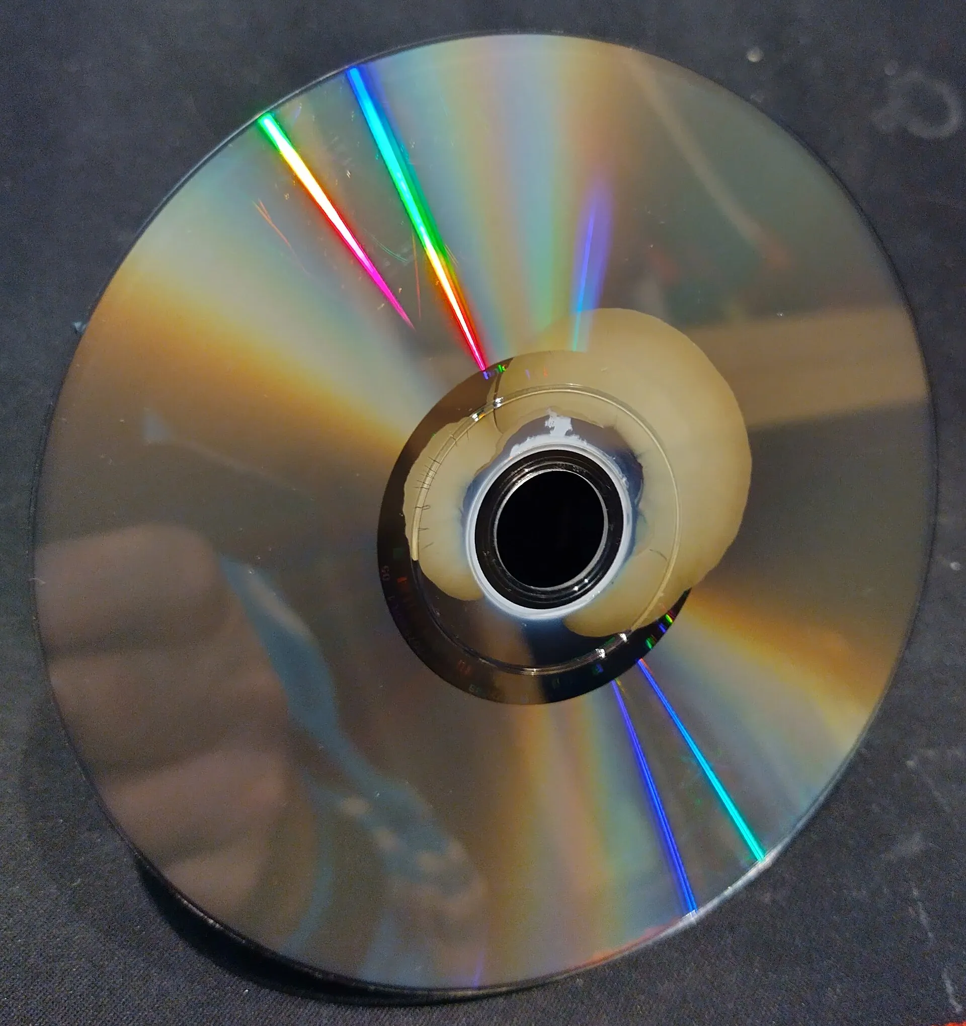 The playing side of a DVD whose reflective layer has corroded outward from the center